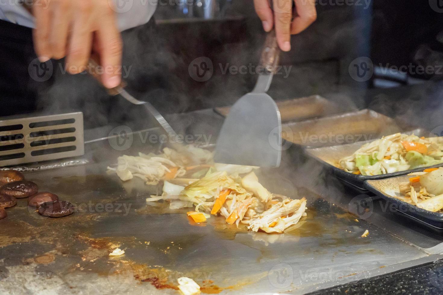 japansk kock matlagning kött och vegetabiliska i teppanyaki restaurang foto