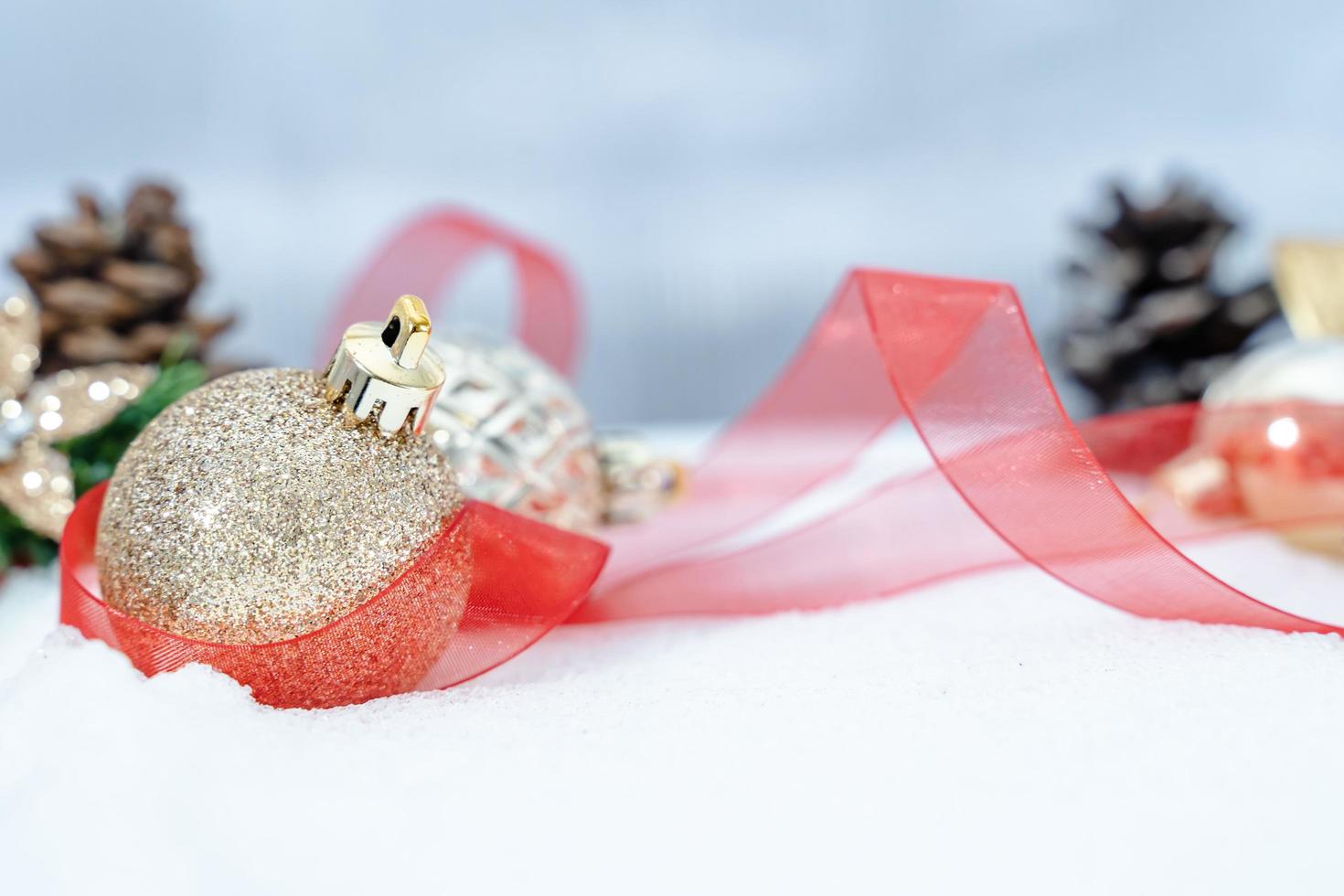 jul av vinter- - jul bollar med band på snö, vinter- högtider begrepp. jul röd bollar, gyllene bollar, tall och snöflingor dekorationer i snö bakgrund foto