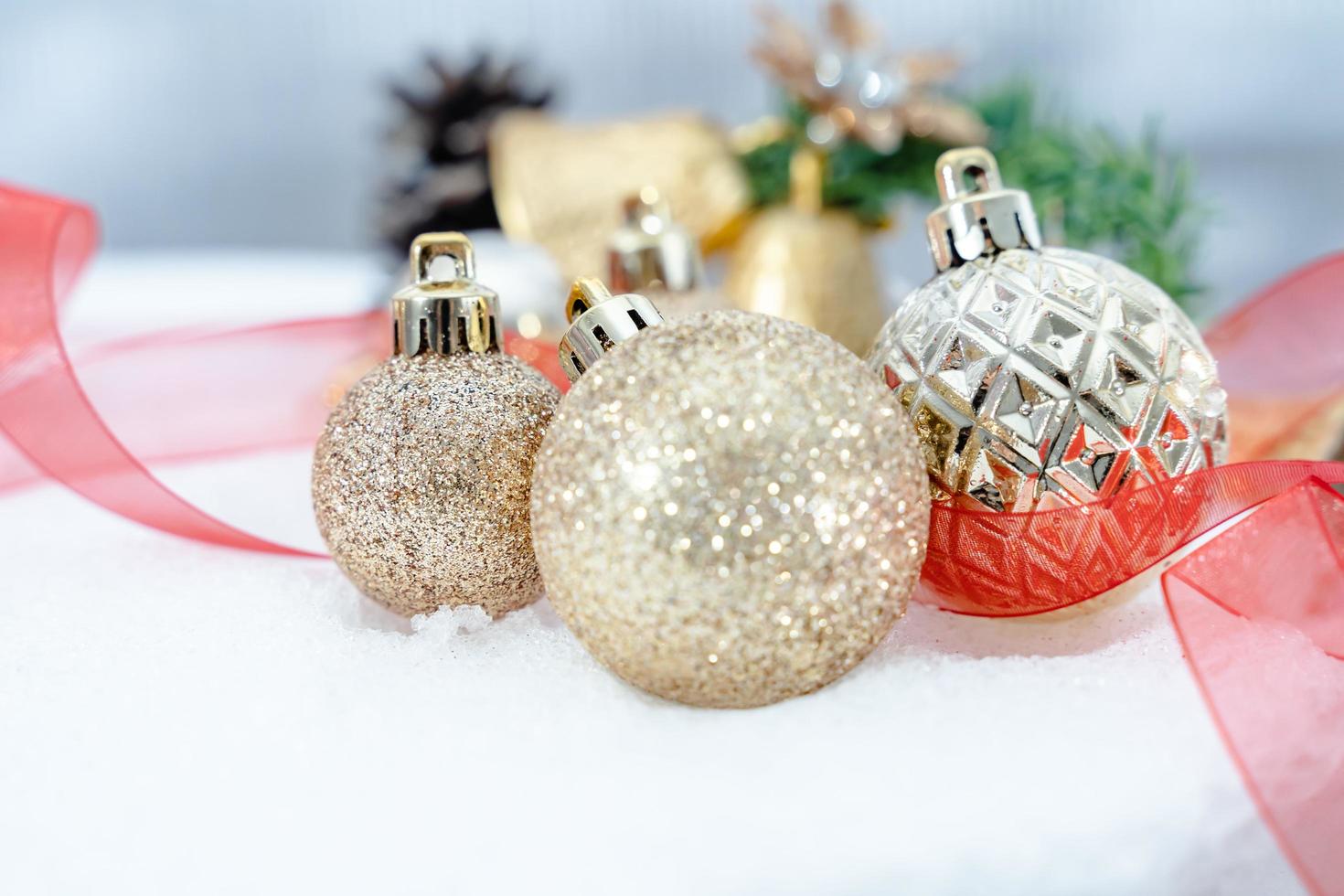 jul av vinter- - jul bollar med band på snö, vinter- högtider begrepp. jul röd bollar, gyllene bollar, tall och snöflingor dekorationer i snö bakgrund foto