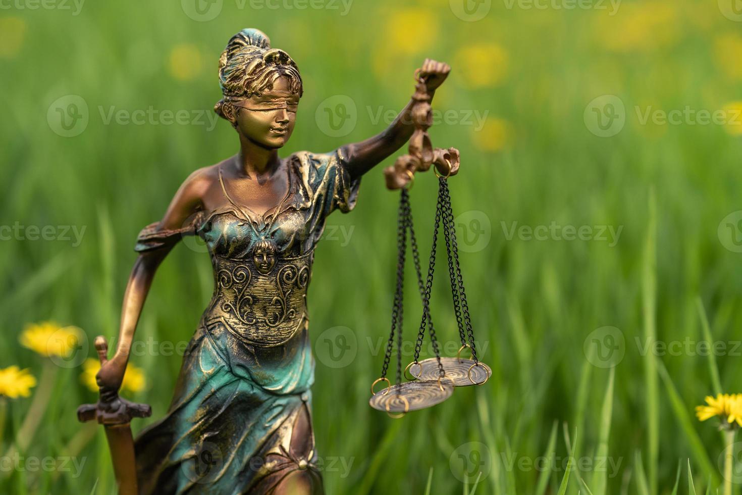 staty av themis på en grön gräs bakgrund. symbol av rättvisa och lag, brottslighet och bestraffning. foto