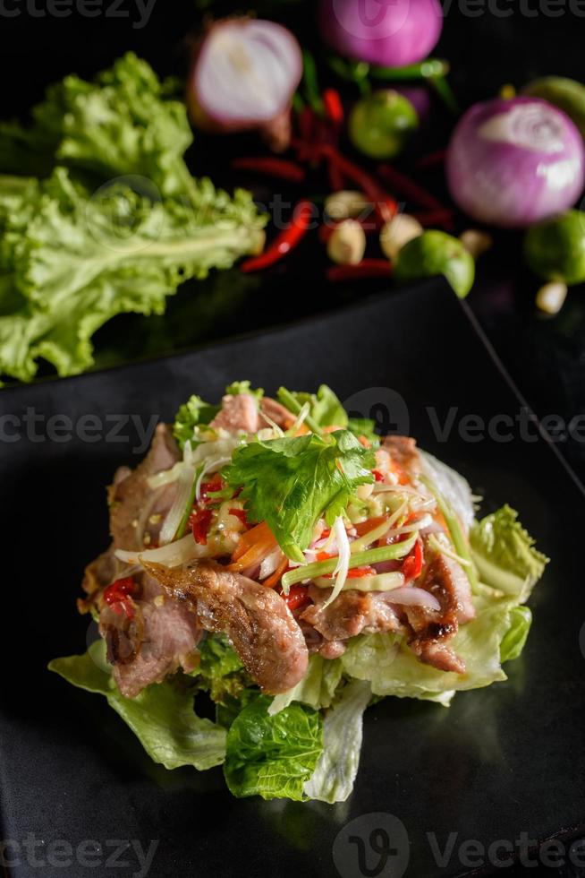 grillad fläsk sallad med grönsaker och kalk, chili, fisk sås, thai mat smak, kryddad, ljuv och sur foto