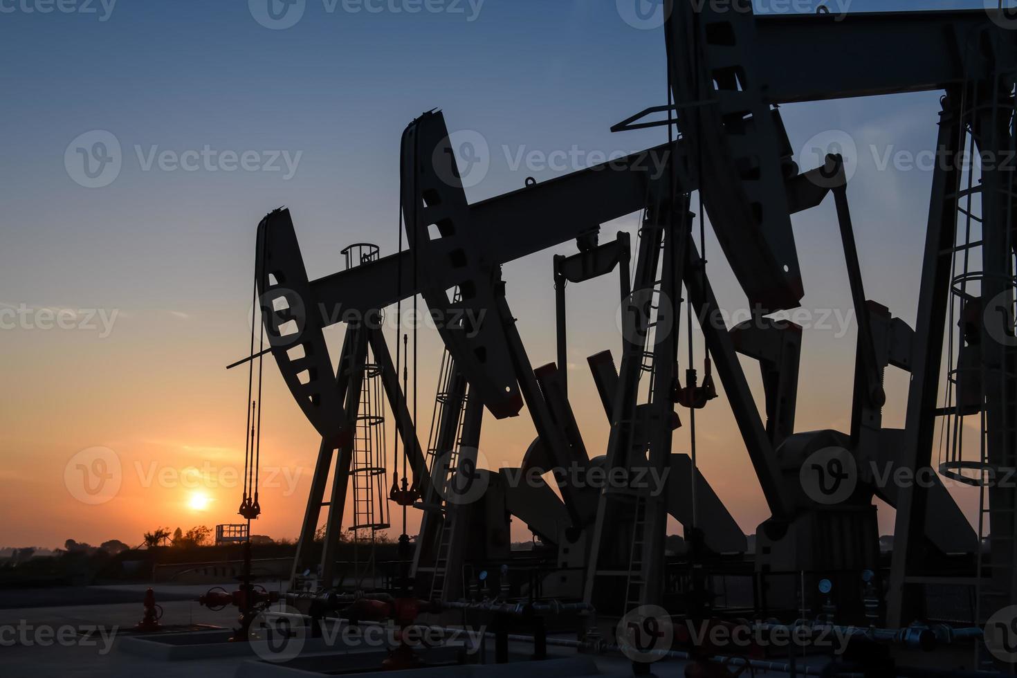 olja rigg eller olja fält webbplats, i de morgon- eller kväll, olja pumps är löpning, de olja pump och de skön solnedgång eller soluppgång av pumpning enhet. foto
