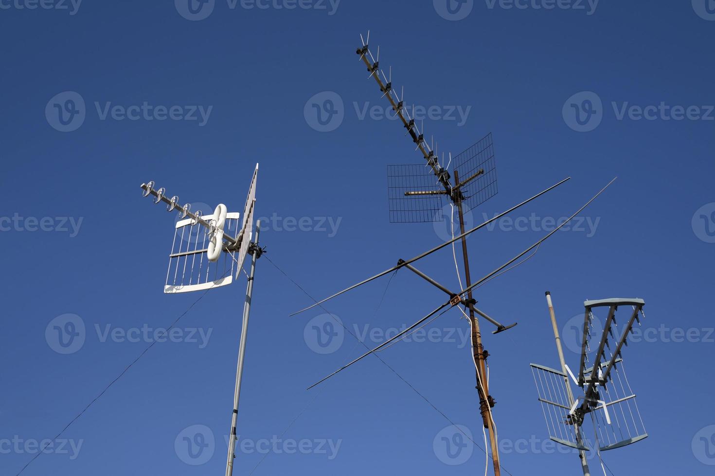 tre antenner mot en blå himmel foto