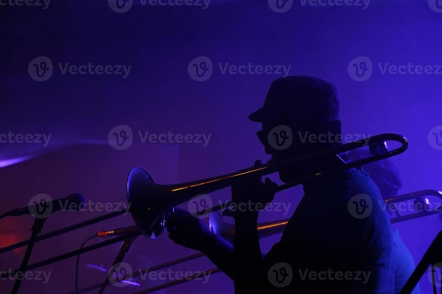 silhuett av en jazz musiker i en vagt belyst klubb foto