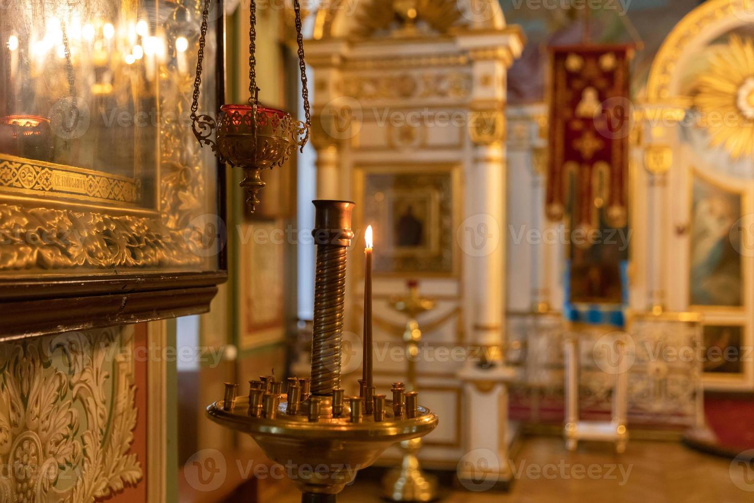 ortodox kyrka. kristendomen. festlig inredning med brinnande ljus och ikon i traditionell ortodox kyrka på påskafton eller jul. religion tro ber symbol. foto