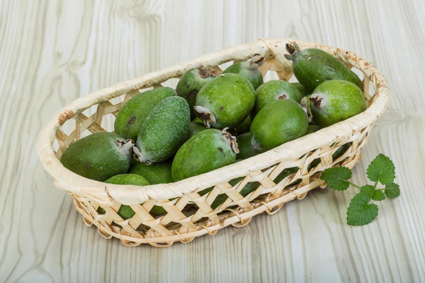 feijoa i en korg på trä- bakgrund foto