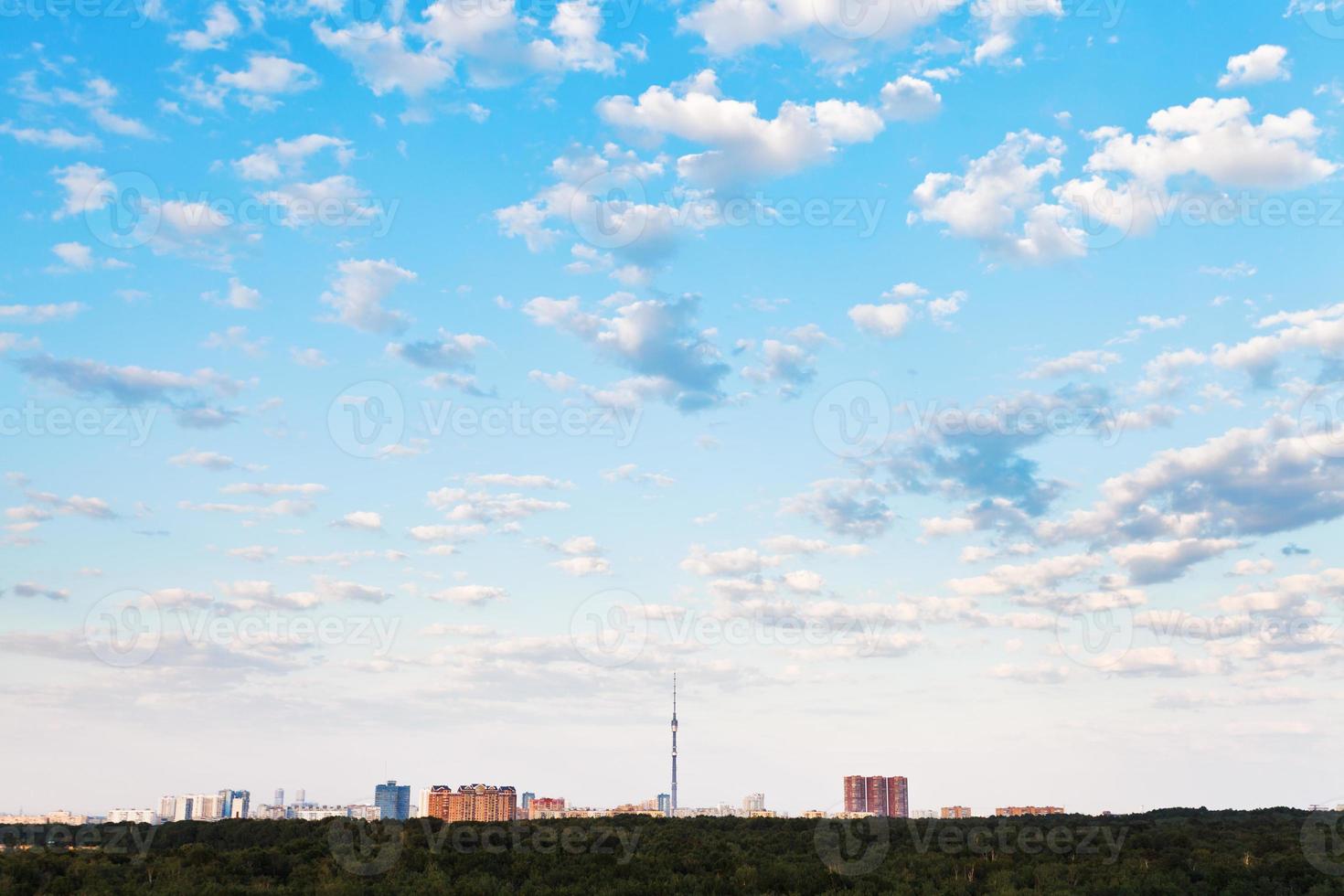 många små vit moln i blå himmel över stad foto