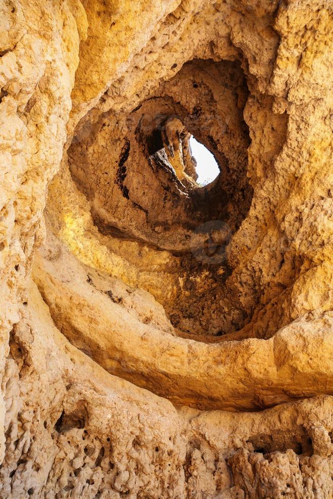 hål i eroderade sandsten sten nära albufeira foto