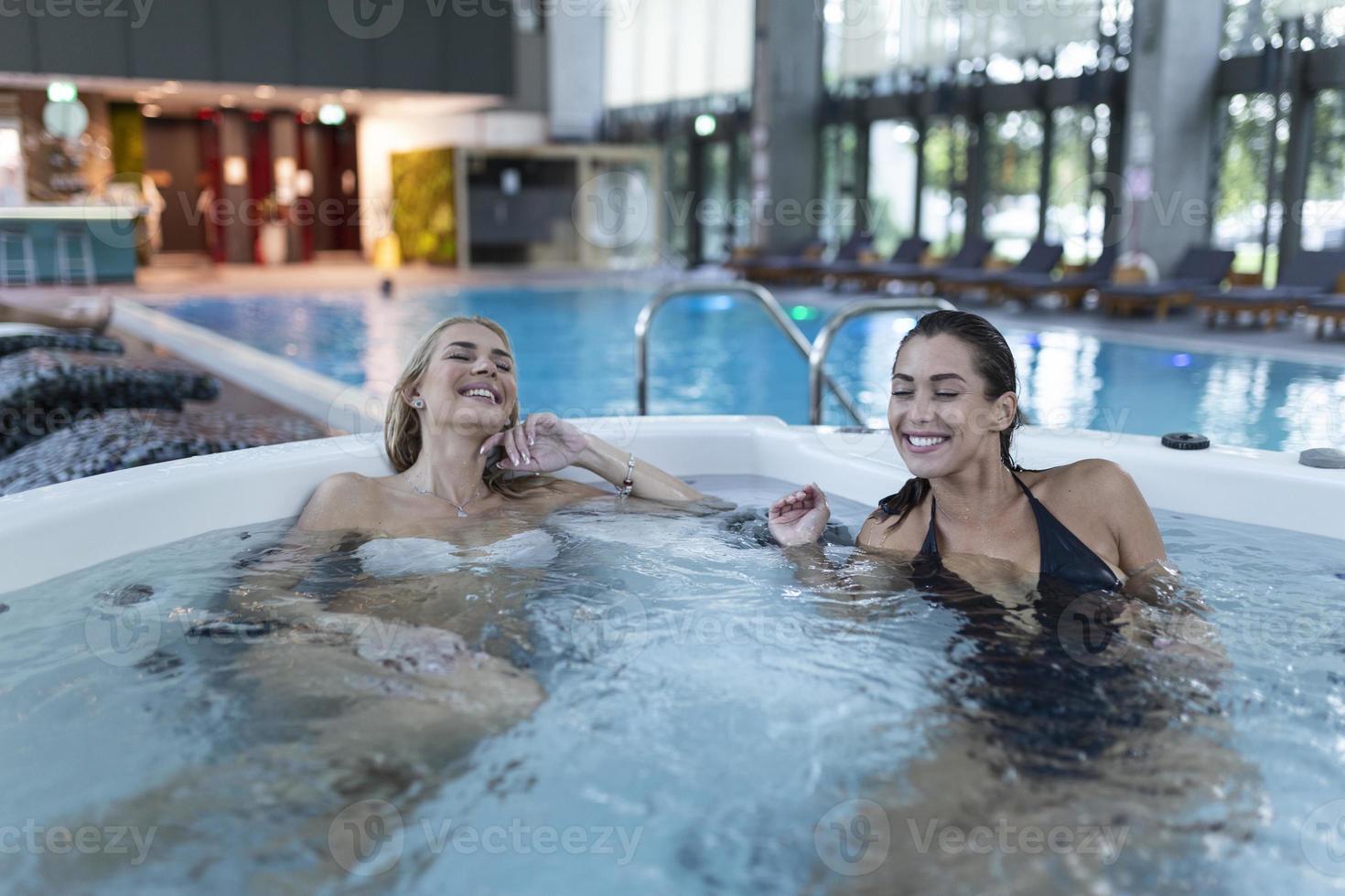 två ung kvinnor njuter och avkopplande i spa varm rör. foto