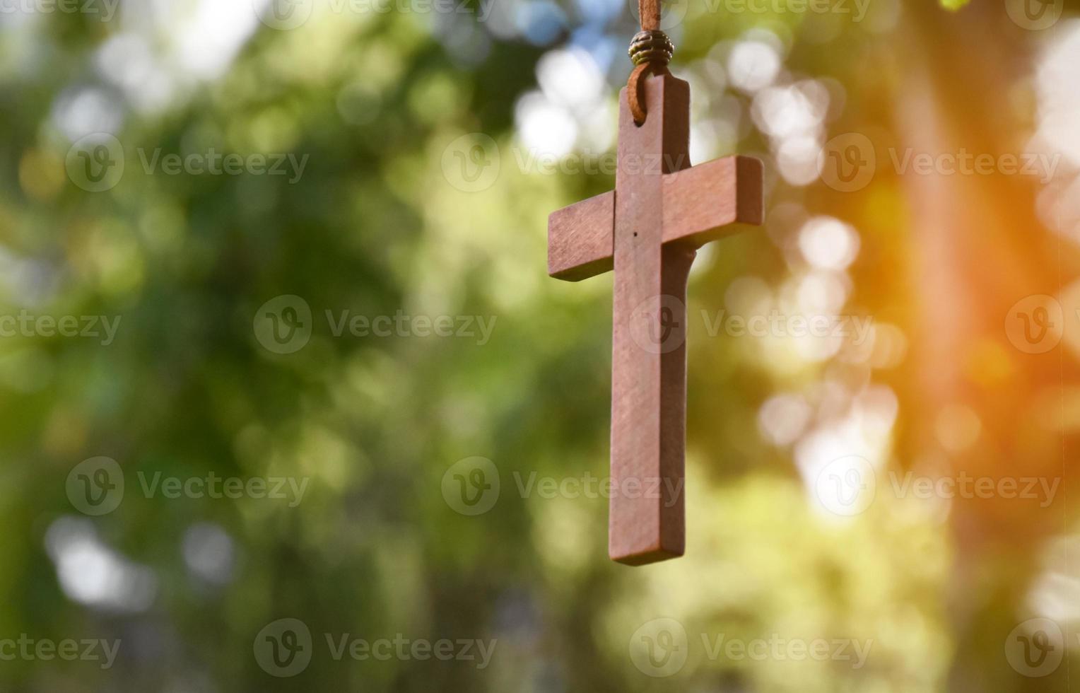 trä- korsa hängande på träd gren, mjuk och selektiv fokus, naturlig bokeh träd bakgrund, begrepp för hoppas, kärlek, förlåtelse och tro i Jesus runt om de värld. foto