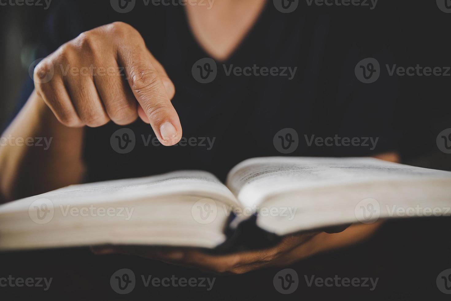 ung kvinna person hand innehav helig bibel med studie på Hem. vuxen kvinna kristen läsning bok i kyrka. flicka inlärning religion andlighet med be till Gud. begrepp av studerande utbildning tro. foto