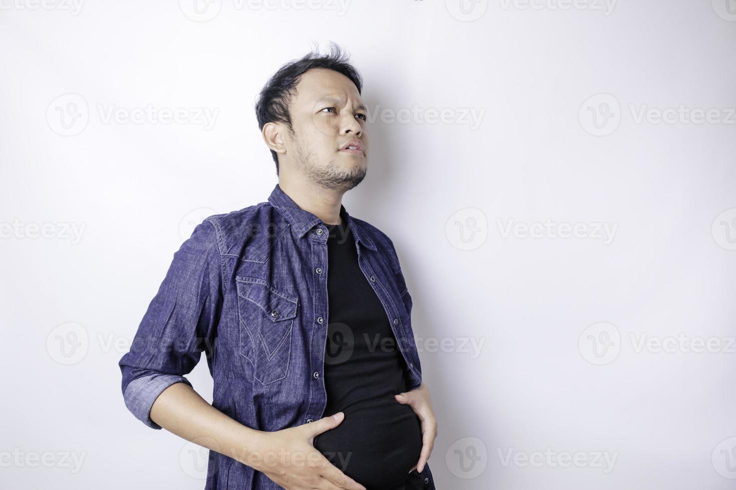 en porträtt av osäker asiatisk fett man är innehav de fett runt om hans midja foto