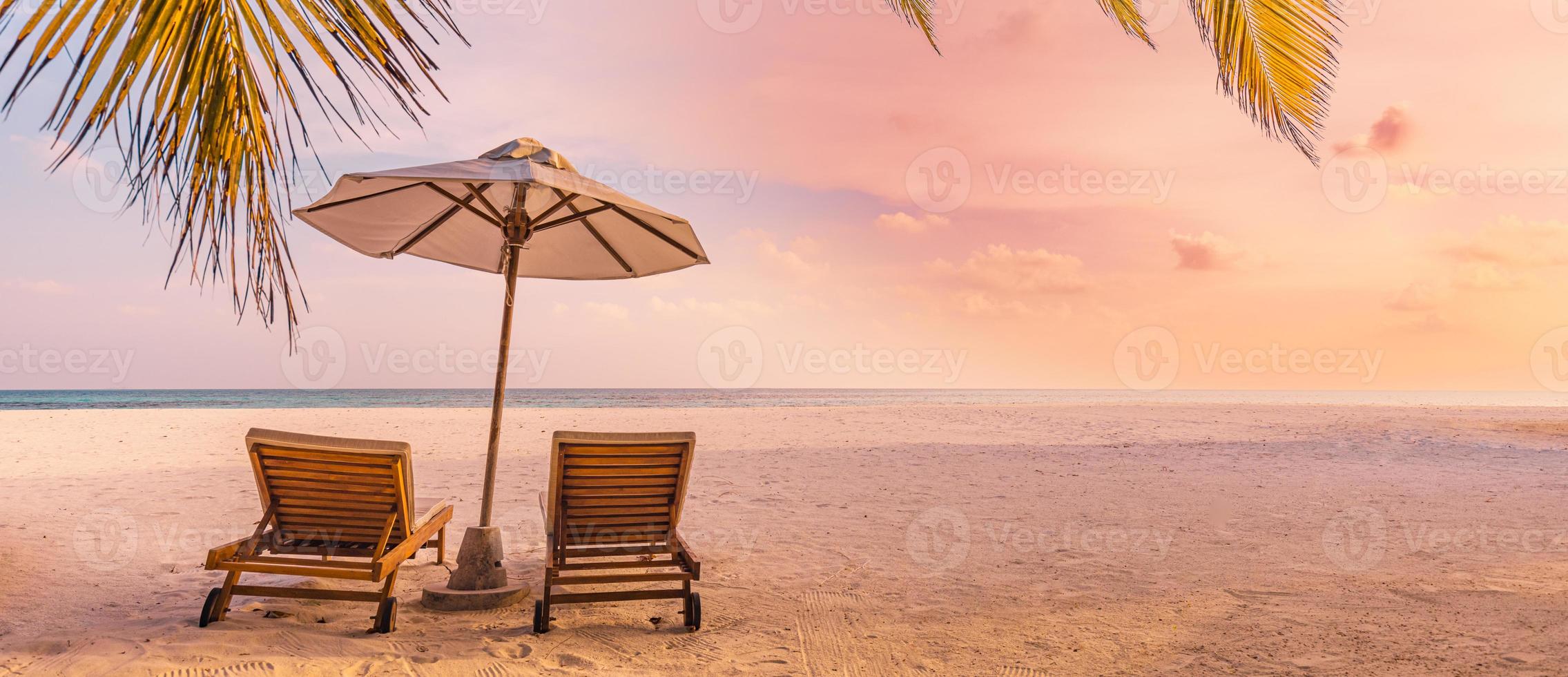 vacker panoramanatur. tropisk strand solnedgång som sommarön landskap med stolar paraply palmblad lugna kusten, kusten. lyx resor panoramisk destination banner för semester eller semester foto