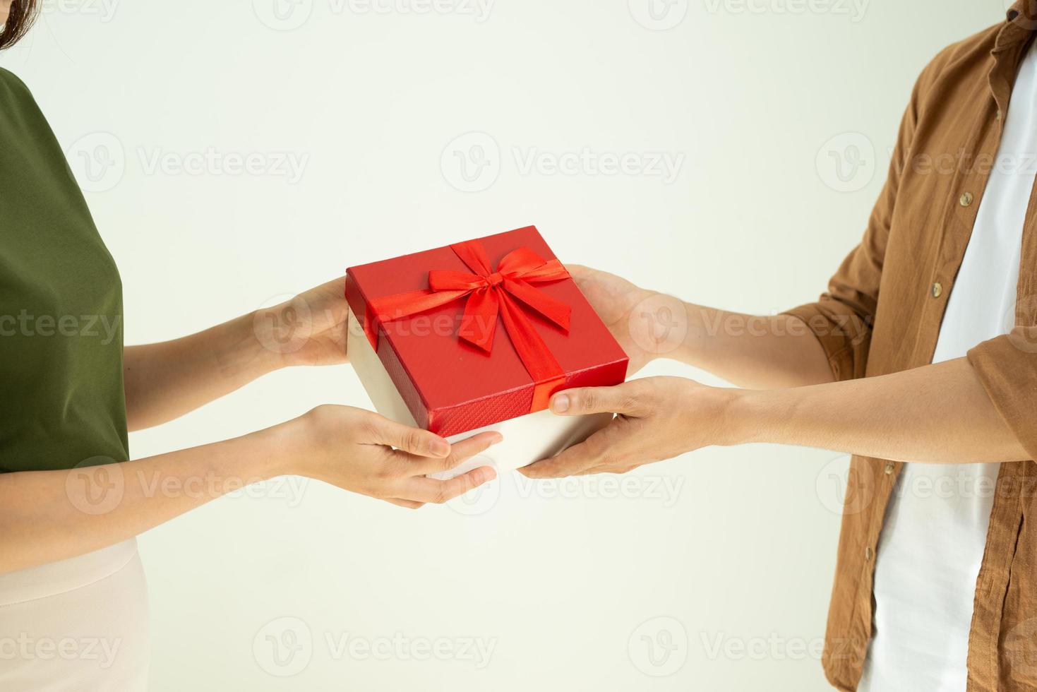 närbild av man ger röd gåva låda till kvinna över vit bakgrund foto