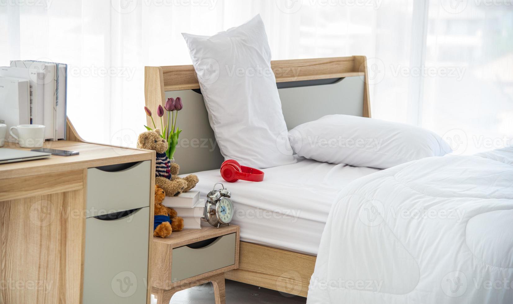 den moderna eller minimala inredningen i sovrummet dekorerad med bekväm dubbelsäng, vita sängkläder som filt, kuddar och trämöbler foto