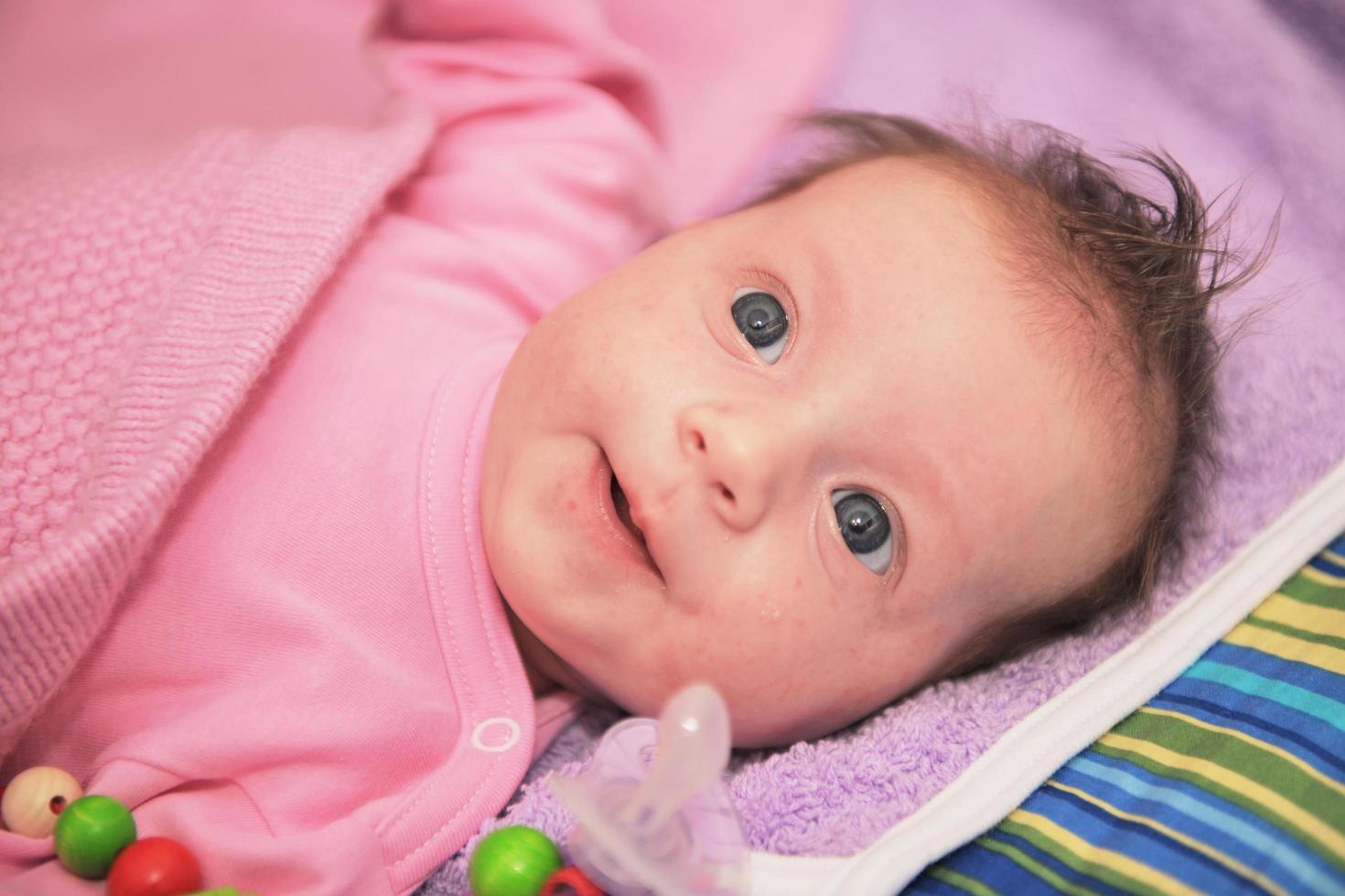 Lycklig nyfödd liten bebis smilling foto