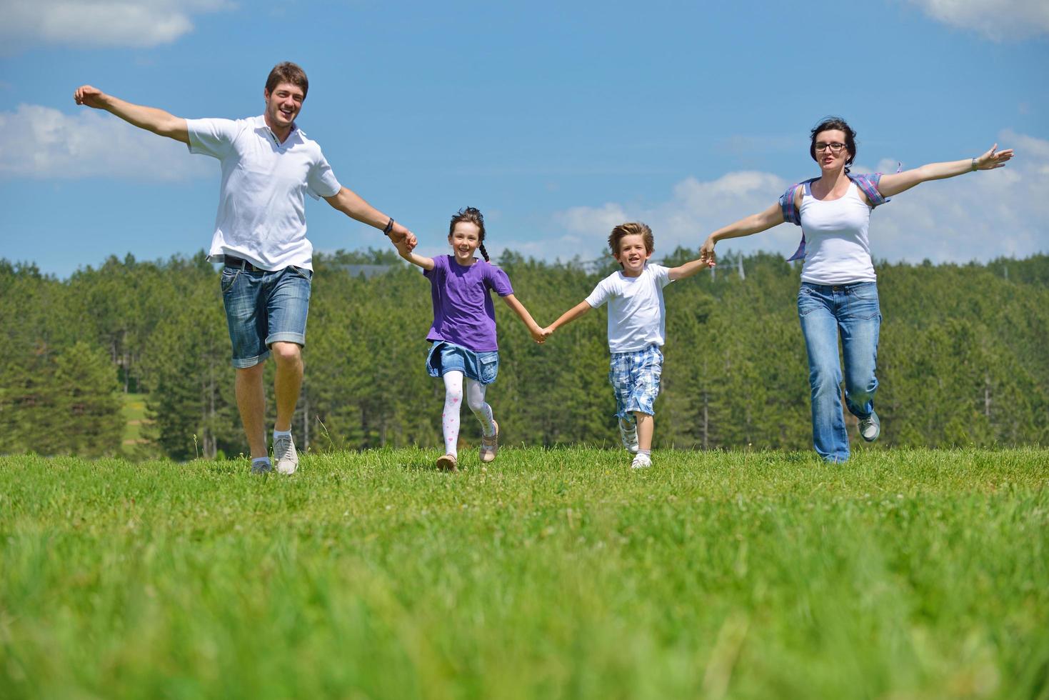 Lycklig ung familj ha roligt utomhus foto