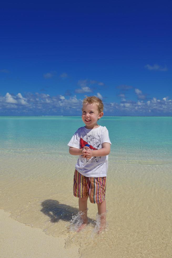 Lycklig ung unge på strand foto