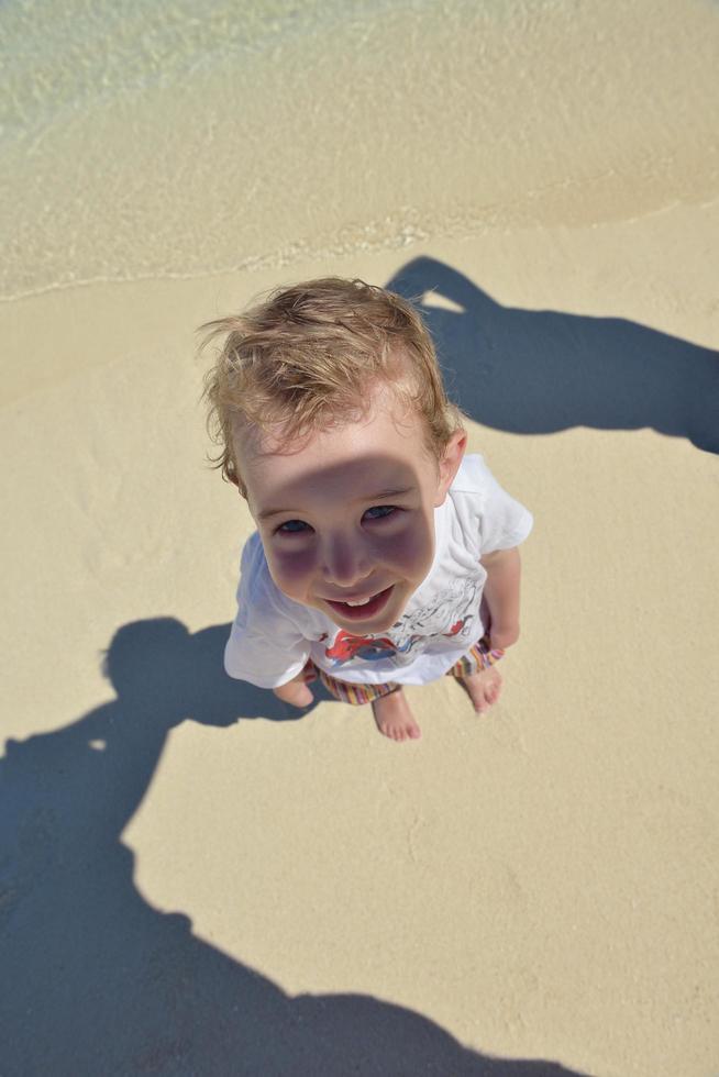 Lycklig ung unge på strand foto