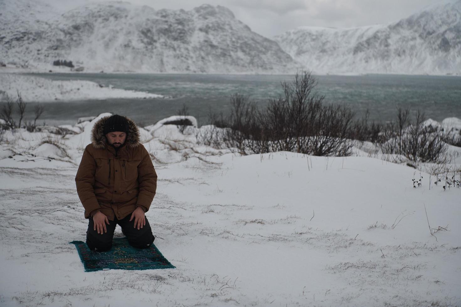 muslimsk resenär som ber i kall snöig vinterdag foto