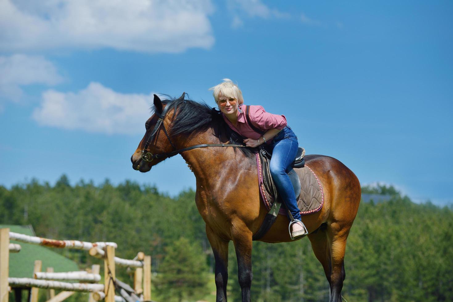 Lycklig kvinna rida häst foto