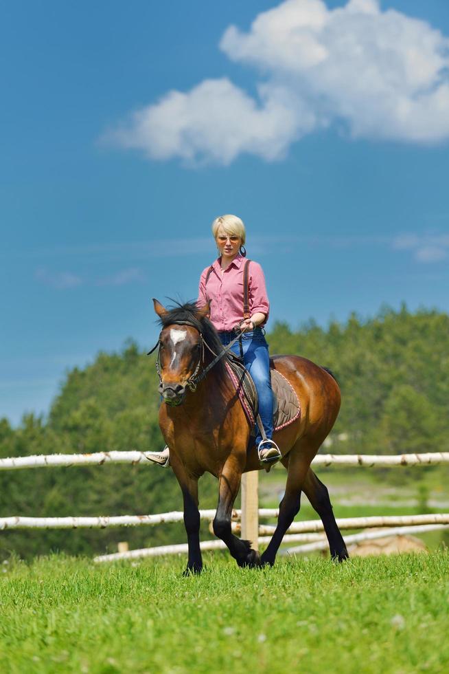 Lycklig kvinna rida häst foto