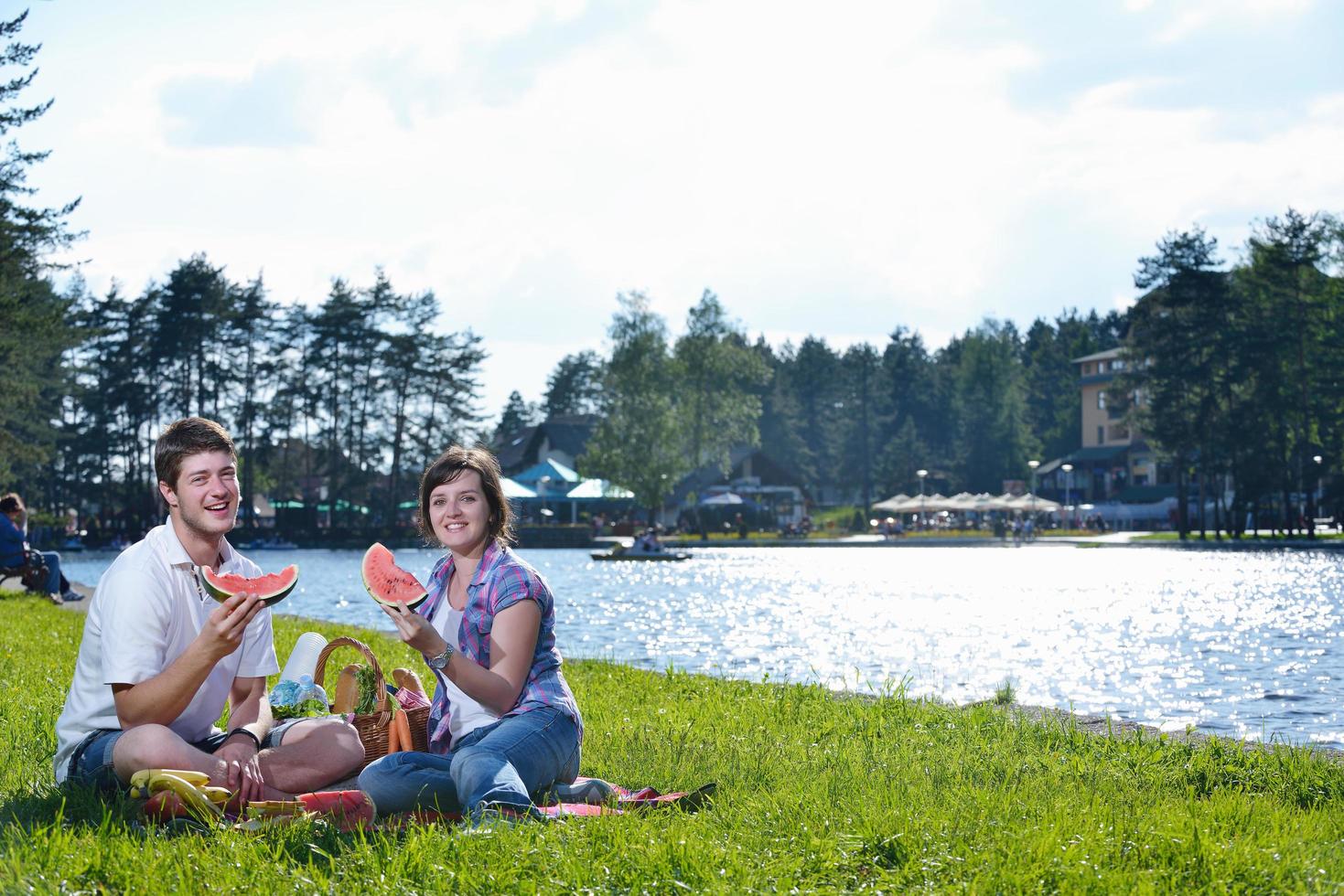 Lycklig ung par har en picknick utomhus- foto