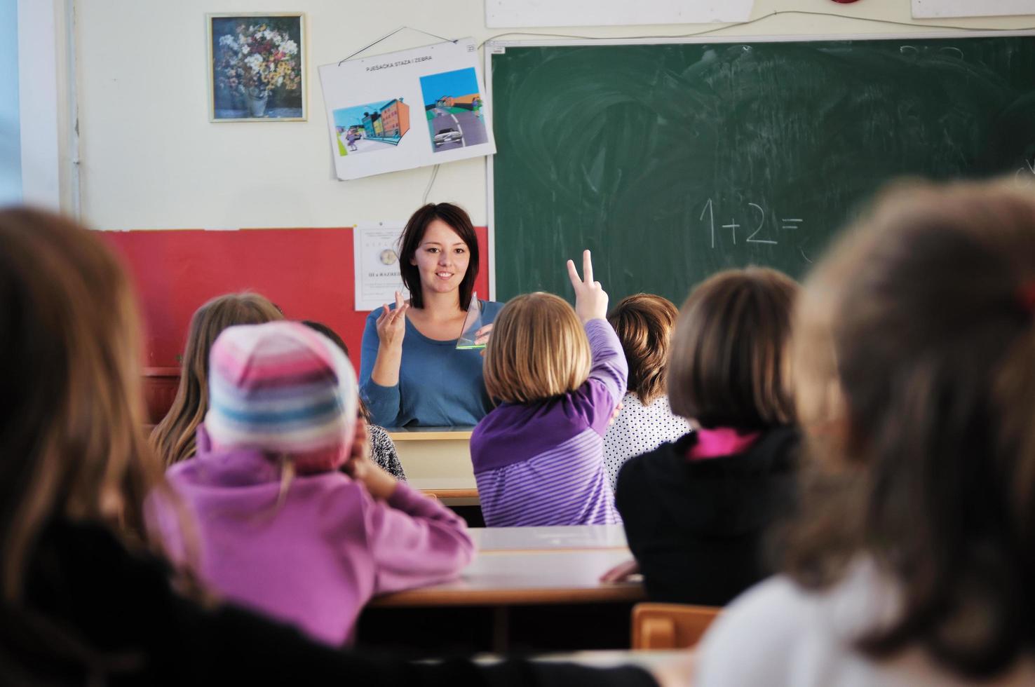 Lycklig lärare i skola klassrum foto