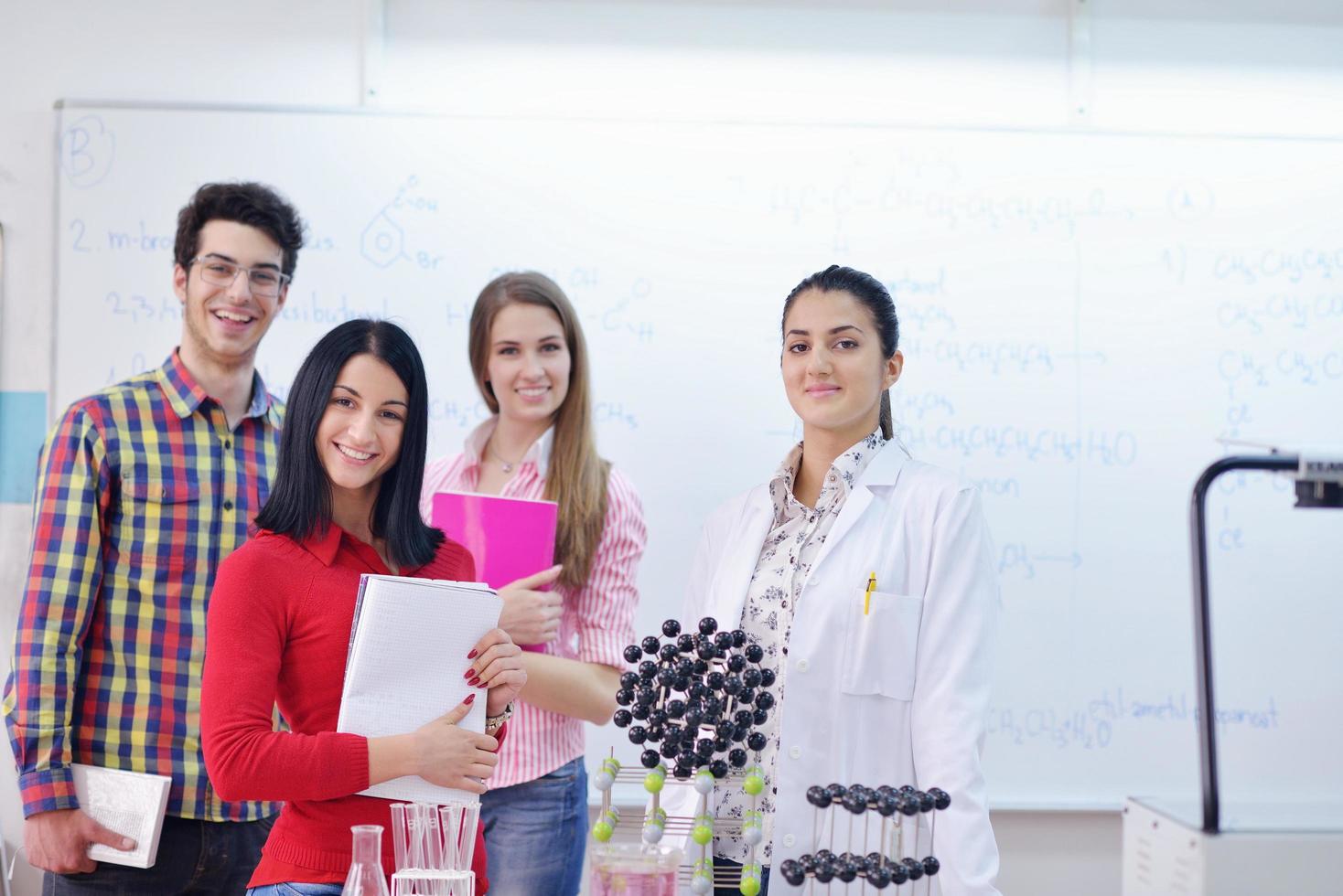 Lycklig tonåren grupp i skola foto