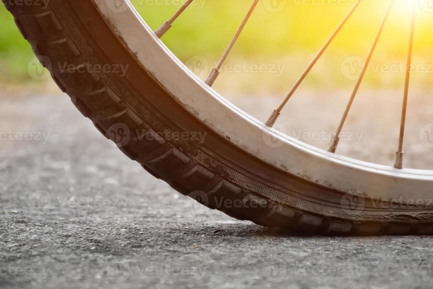 stänga upp se av cykel som har platt däck och parkerad på de trottoar, suddig bakgrund. mjuk och selektiv fokus på däck. foto