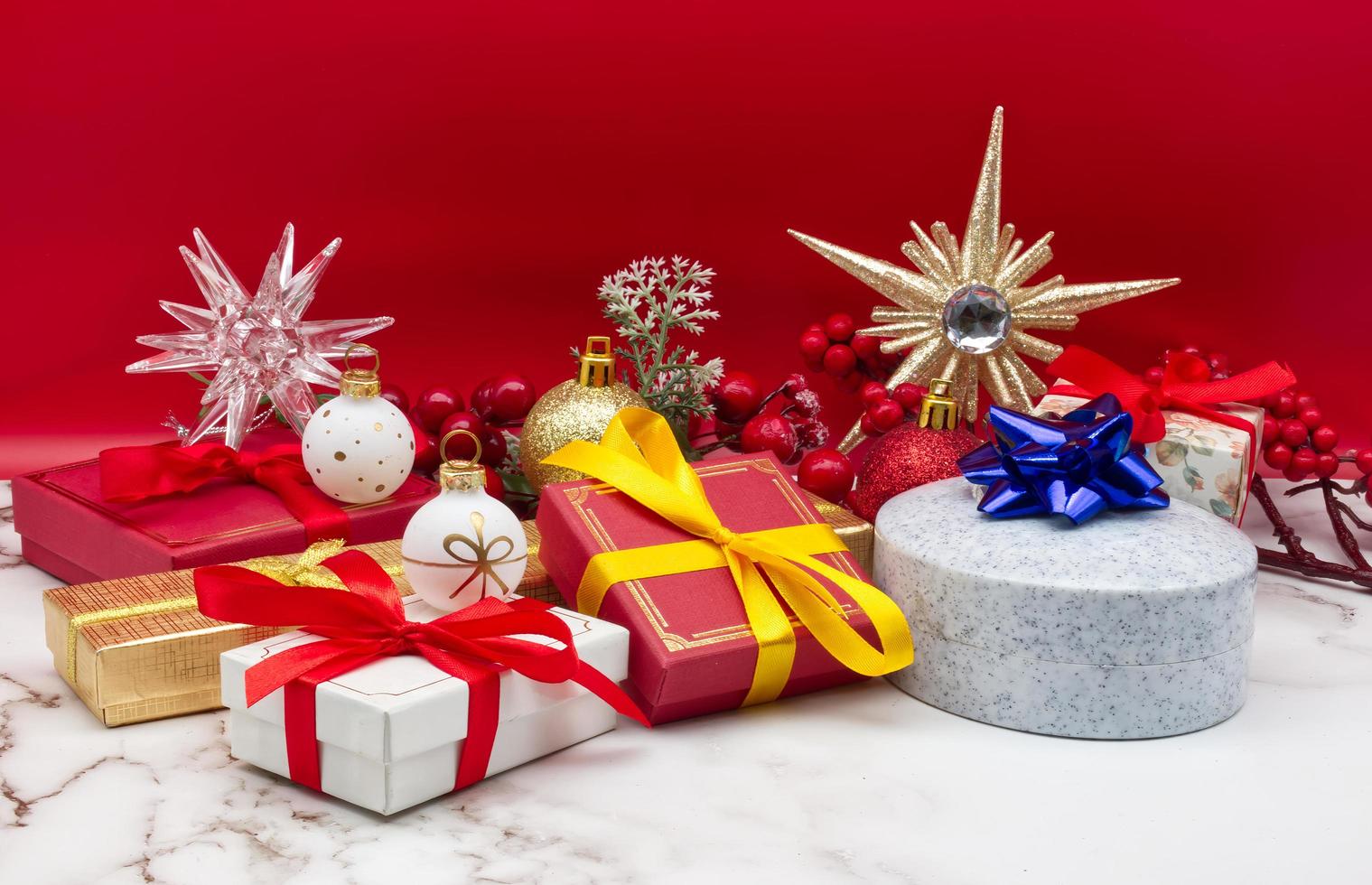 jul gåva lådor isolerat på marmor tabell och röd bakgrund foto