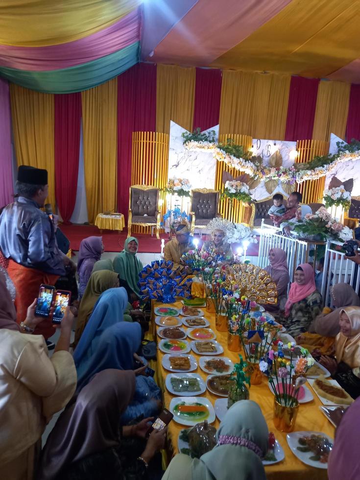medan, indonesien 23 januari 2022 i ett traditionellt bröllop i norra Sumatran i Malay är det en traditionell ceremoni där man äter ris framför bruden och hennes familj foto