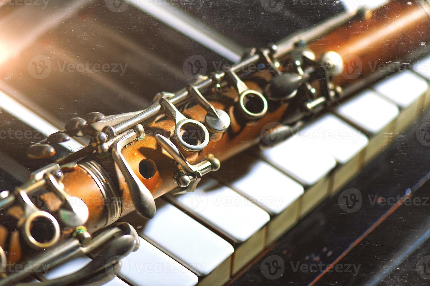 årgång effekt fotografera. antik klarinett lutande på piano tangentbord foto
