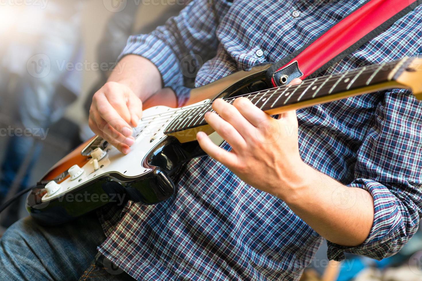 elektrisk gitarrist av en ung grupp under en visa foto