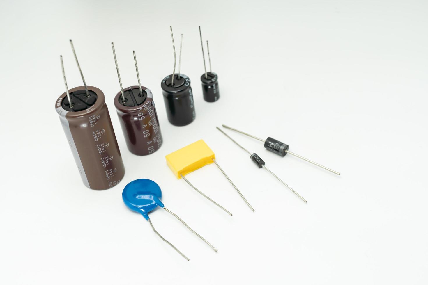 grupp av olika elektroniska komponenter diod kondensatorer resistorer lysdioder. isolerad på vit bakgrund foto