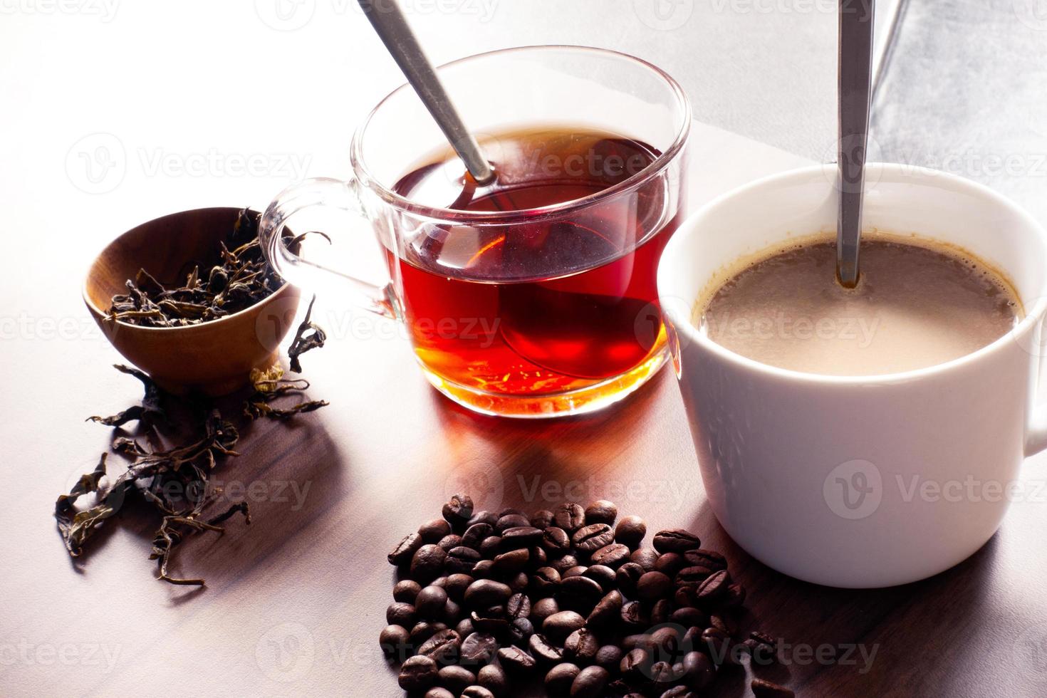 kaffe och te med kaffebönor och teblad på trägolv. foto