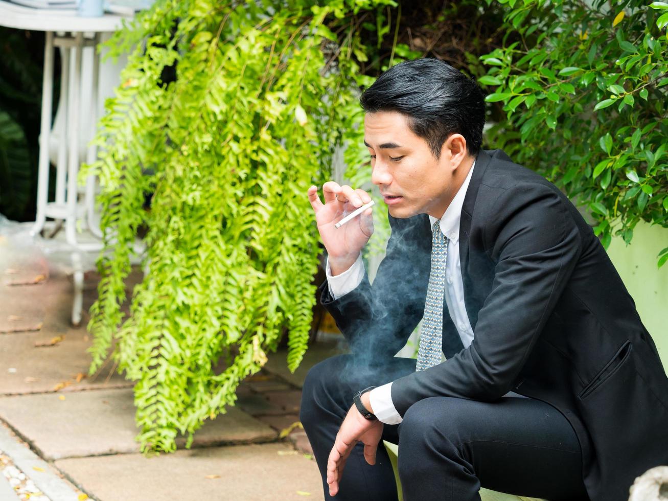 ung affärsman röker och tänker på affärsfrågor foto