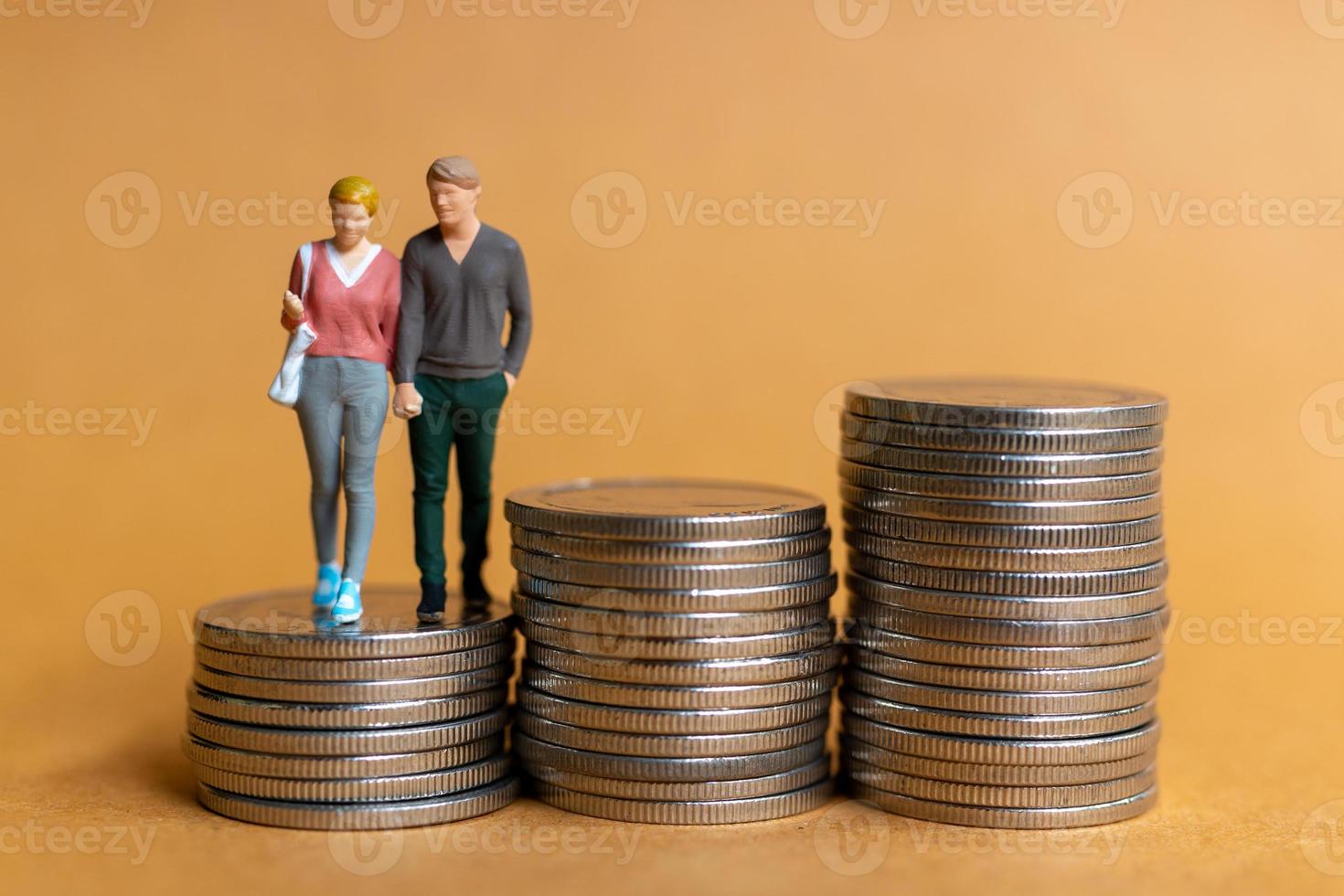 miniatyr människor, lyckligt par stående på mynt stack foto