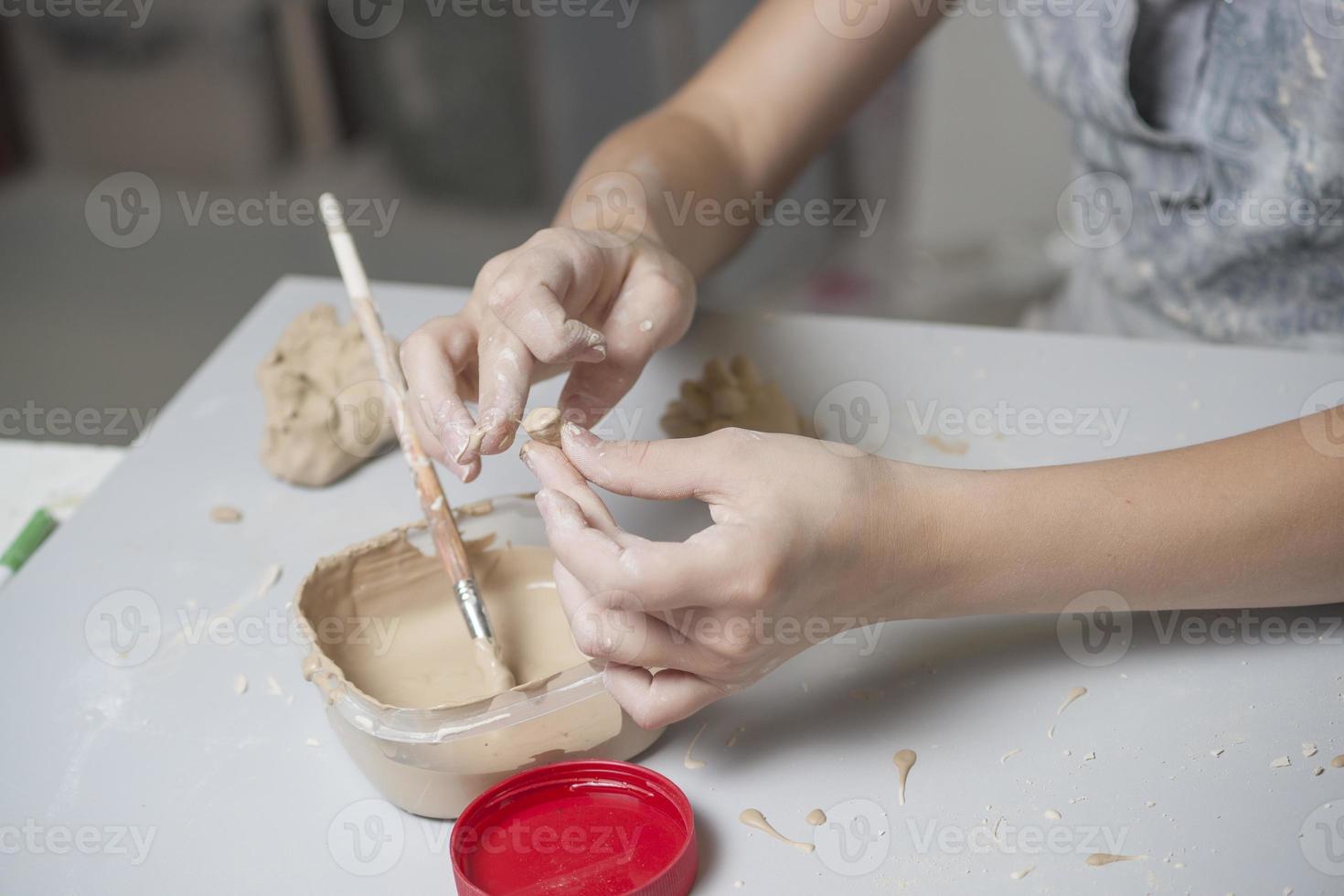 flicka gör leksak från lera foto