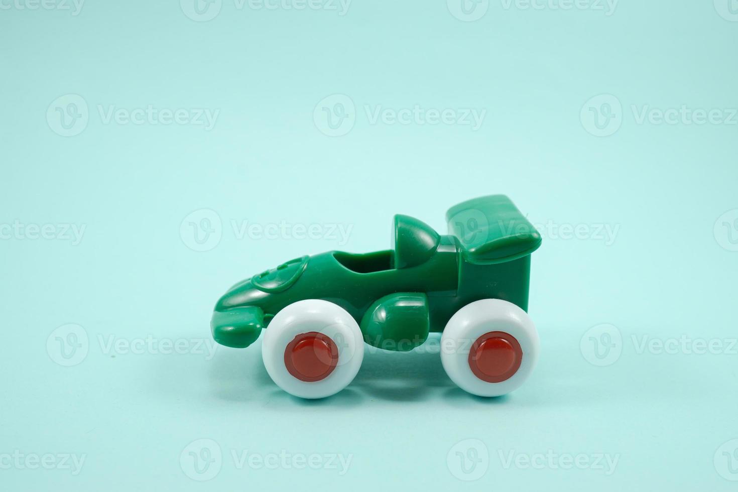 grön måla plast leksak tävlings bil med siffra ett isolerat på turkos foto