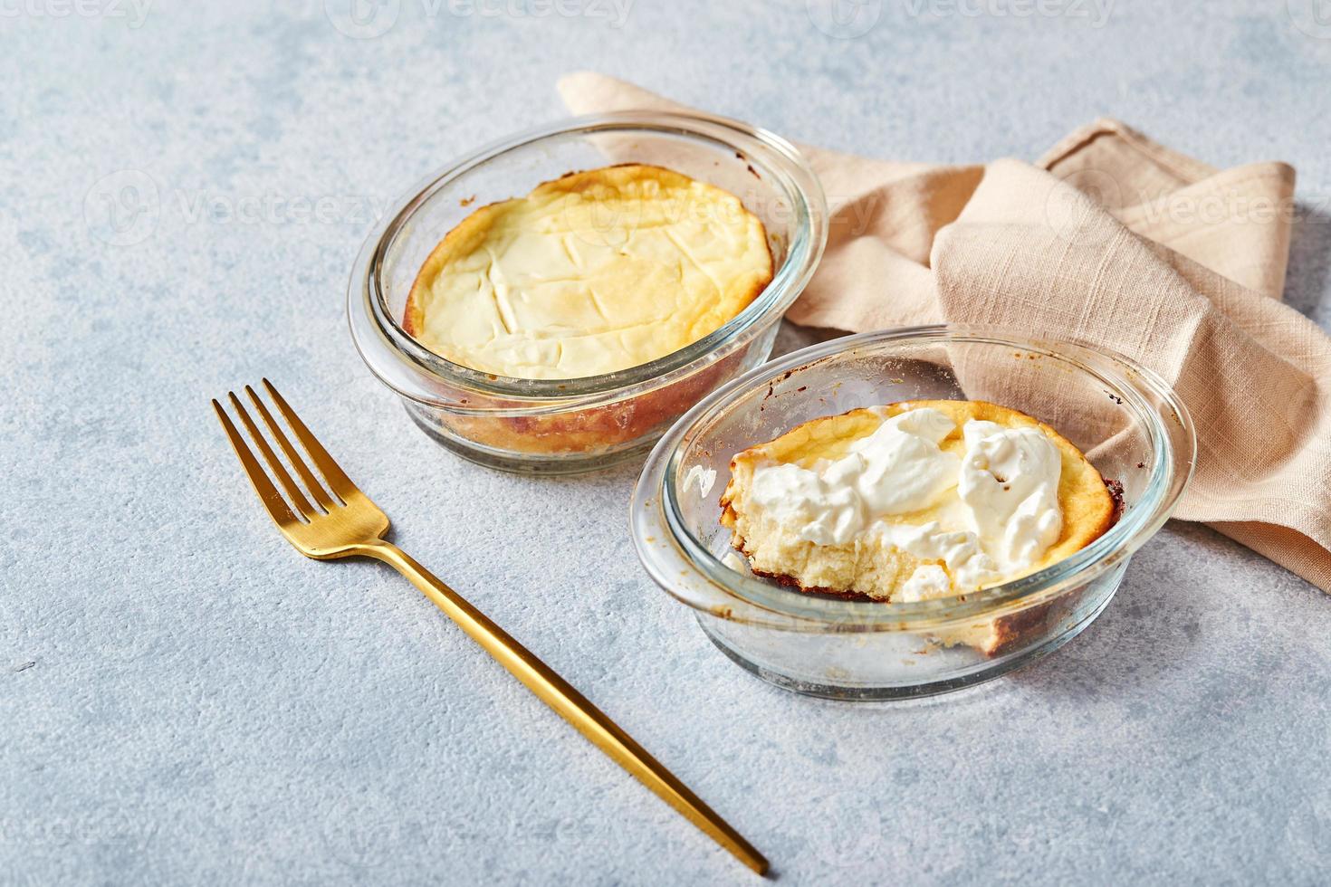 utsökt stuga ost gryta i portionerad glas former med sur grädde. traditionell ryska kök för frukost - zapekanka foto