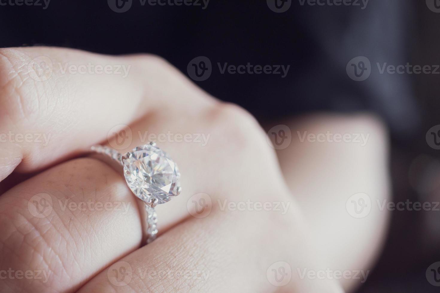 engagemang diamant ringa på kvinna finger närbild foto