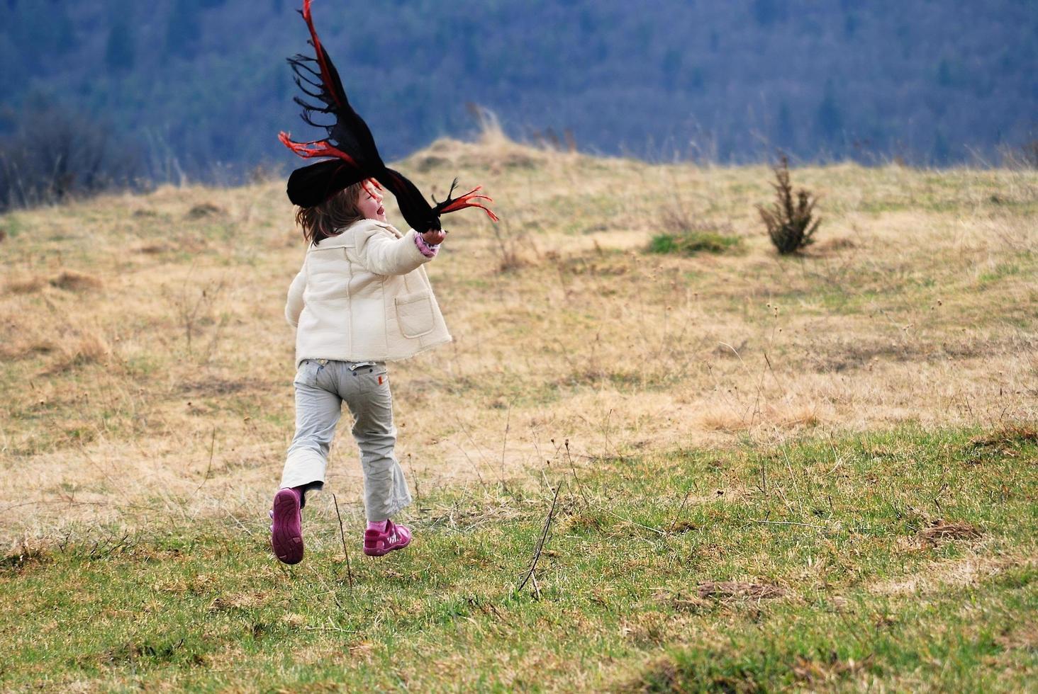 skön löpning flicka på äng med vind i deras hår foto