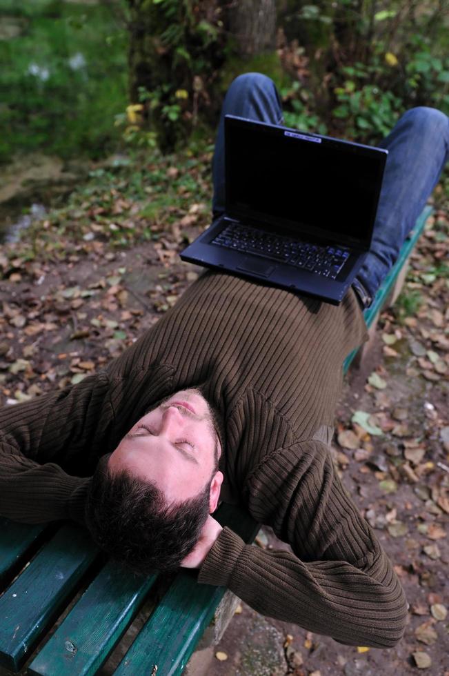 ung affärsman arbetssätt på bärbar dator utomhus- foto