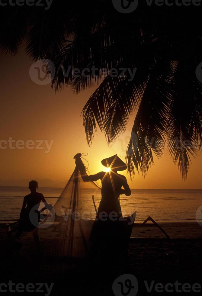 fiskares silhuetter, indonesien, på den tropiska stranden vid solnedgången foto
