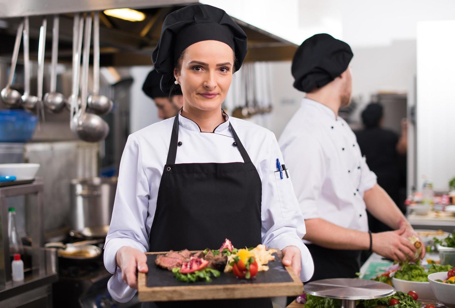 kvinna kock innehav nötkött biff tallrik foto