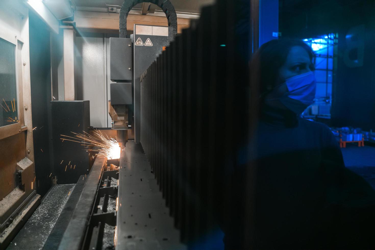 Kalkon, 2022 - gnistor flyga ut maskin huvud för metall bearbetning laser metall på metallurgisk växt bakgrund. tillverkning färdiga delar för bil- produktion begrepp foto