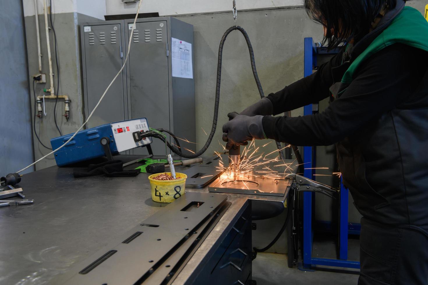 en kvinna arbetssätt i de modern metall produktion och bearbetning industri svetsar de produkt och förbereder den för en cnc maskin foto