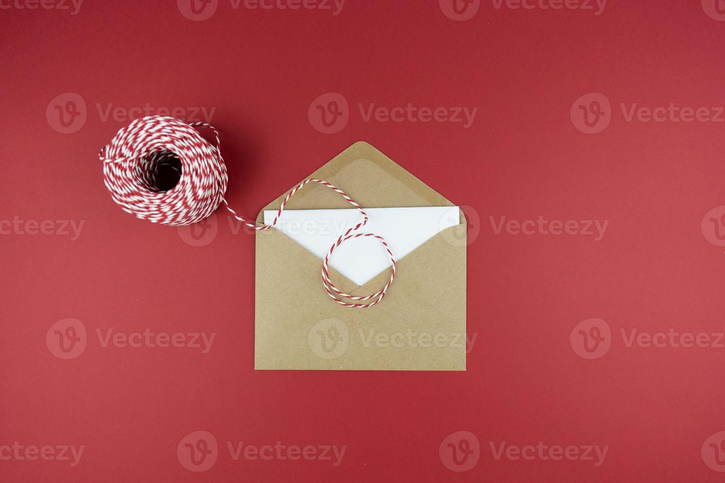 ett kuvert med en brev liggande på en röd bakgrund som en hälsningar för högtider foto