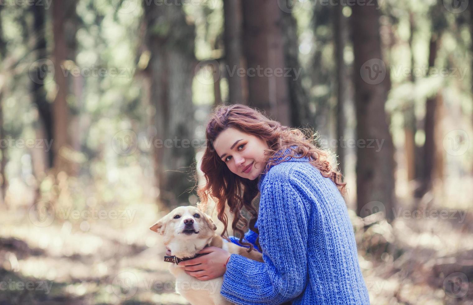 kvinna i Tröja med hund i skog foto